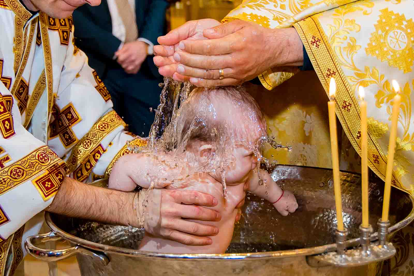 copil tinut de preot la botez in biserica